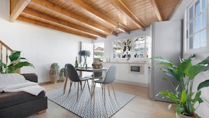 A modern kitchen with wooden beams, a dining area with a patterned rug, and a large potted plant. - Holiday Home 'Casa Evarista' with Sea View, Private Terrace and Wi-Fi (Icod de los Vinos)