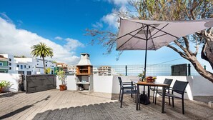 A patio with a table and chairs, a grill, and a potted plant. - Holiday Home 'Casa Evarista' with Sea View, Private Terrace and Wi-Fi (Icod de los Vinos)