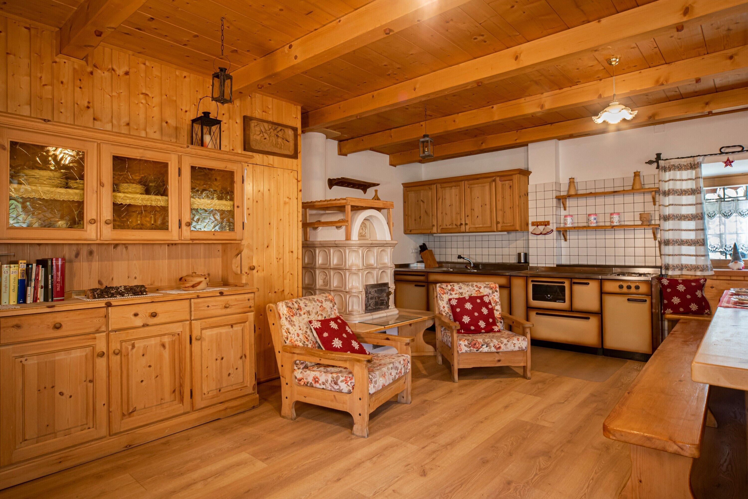 A wooden interior with a kitchen, dining area, and seating.