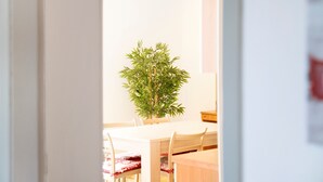 Un espace repas comprenant une table, des chaises et une plante en pot.
