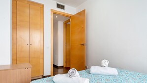 Ein Hotelzimmer mit einem Bett, einem Holzschrank und einer Tür zu einem anderen Raum.