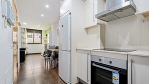 Eine Küche mit Kühlschrank, Backofen und Schränken.