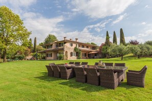 A large house with a spacious lawn, outdoor furniture, and tall trees. - Villa 'Minerva' with Lake View, Wi-Fi and Air Conditioning (Lazise)
