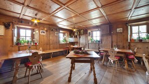 A wooden interior with a dining table, chairs, and a bench.