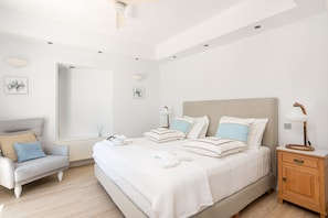 Un dormitorio moderno con cama, mesita de noche y una silla.