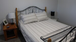 A single bed with a wooden headboard, a bedside table with a lamp, and a picture frame. - SHUSWAP GOLF AND LAKE ESCAPE
 (Blind Bay)