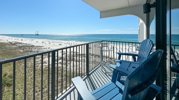 En balkon med udsigt over stranden og havet.
