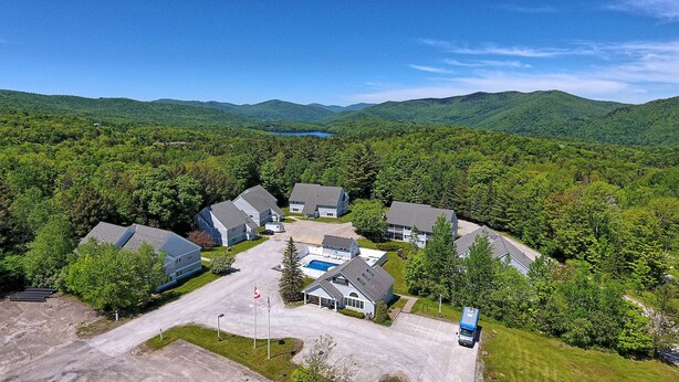 A residential area with houses, a swimming pool, and a mountain backdrop.