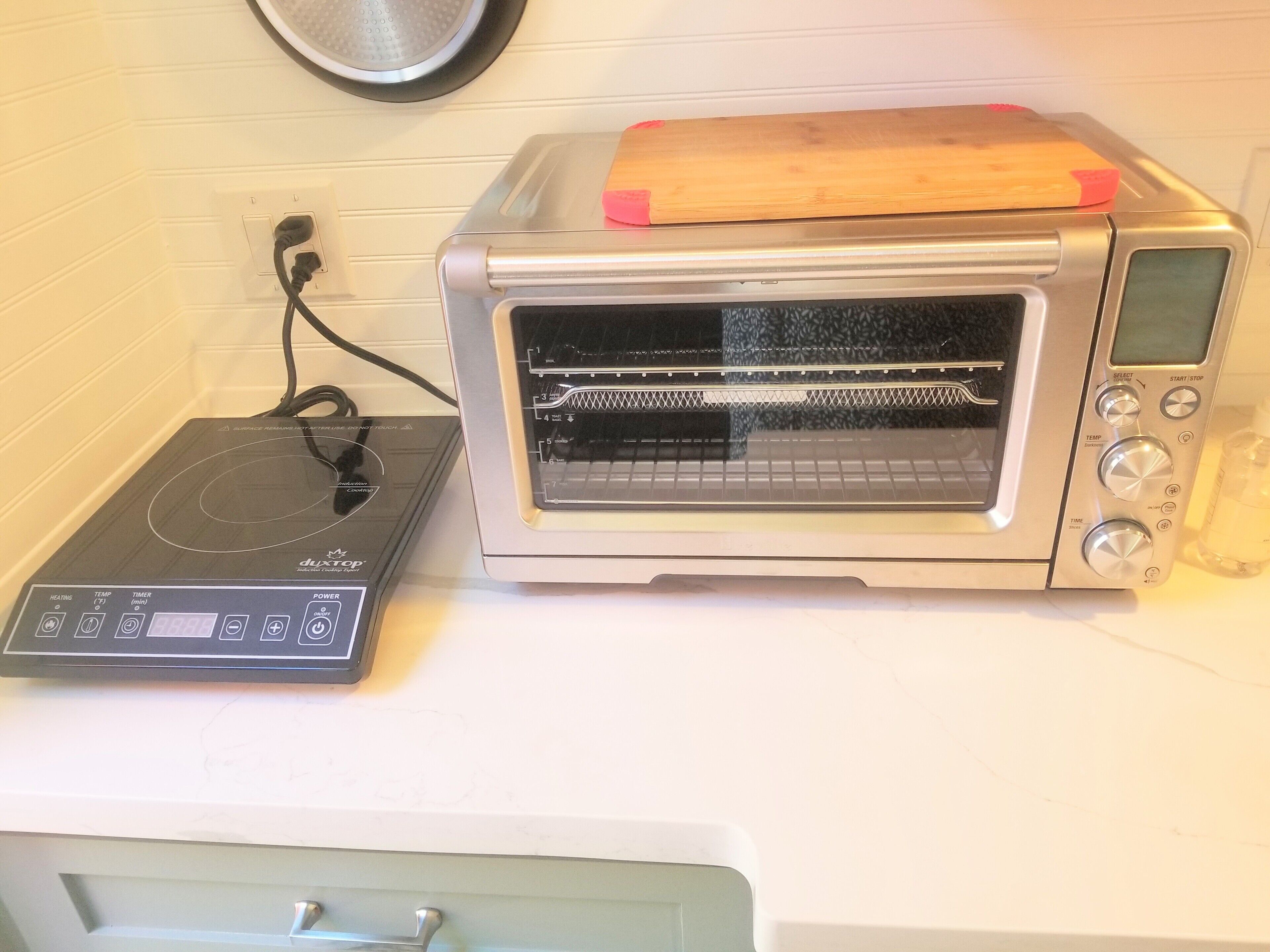A kitchen with a toaster oven and a separate induction cooktop.