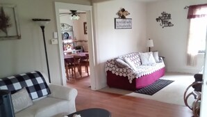 Una sala de estar con un sofá, una mesa de centro y un área de comedor al fondo.
