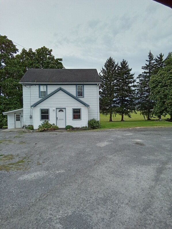 A white two-story house with a gabled roof and a front porch.