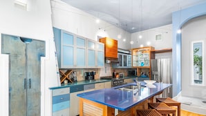 Una cocina moderna con una isla central, taburetes de madera y electrodomésticos integrados.