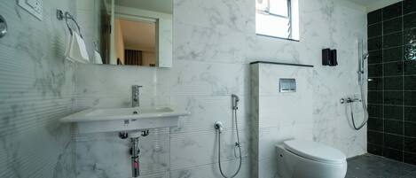 Un baño moderno con lavamanos de mármol, inodoro y ducha.