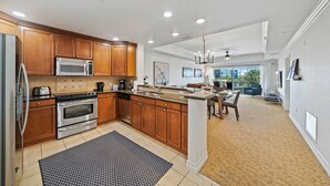 A modern kitchen with wooden cabinets, stainless steel appliances, and a large island.