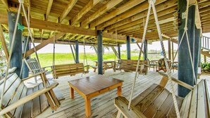 A wooden deck with benches, a table, and rope swings. - Milky Way Beach Front: Coastal Realty Group (Grand Isle)
