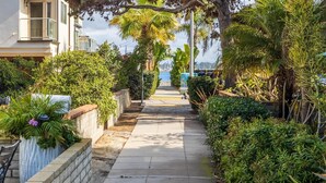 A narrow pathway lined with lush greenery and a view of a marina in the distance. - Fantastic Bayside Vacation Home w/ WiFi, Private Washer/Dryer, Central AC, Patio (San Diego)
