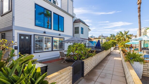 A modern two-story house with a patio area, large windows, and a view of the street. - Fantastic Bayside Vacation Home w/ WiFi, Private Washer/Dryer, Central AC, Patio (San Diego)
