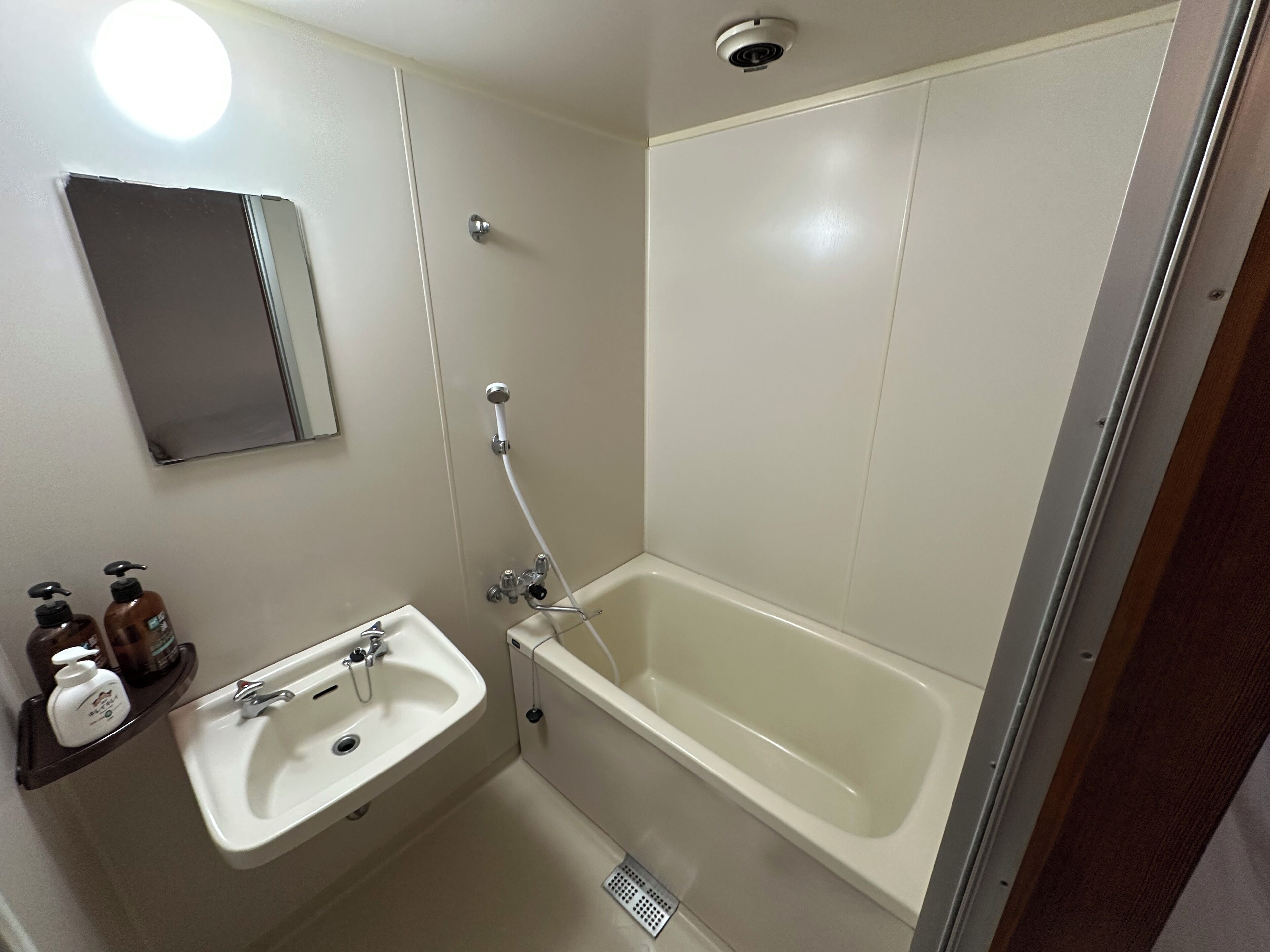 Ein Badezimmer mit Waschbecken, Spiegel und Badewanne.