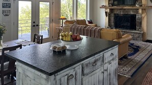 A spacious living area with a large island, a fireplace, and a dining area with a view to the outdoors. -  Secluded Chickalah Mt. retreat overlooking beautiful Harkey Valley! (Belleville)