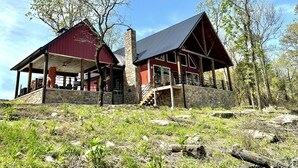 A rustic cabin with a stone foundation, a red exterior, and a covered porch. -  Secluded Chickalah Mt. retreat overlooking beautiful Harkey Valley! (Belleville)