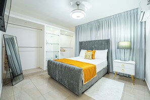 A modern bedroom with a bed, bedside table, and built-in wardrobe.