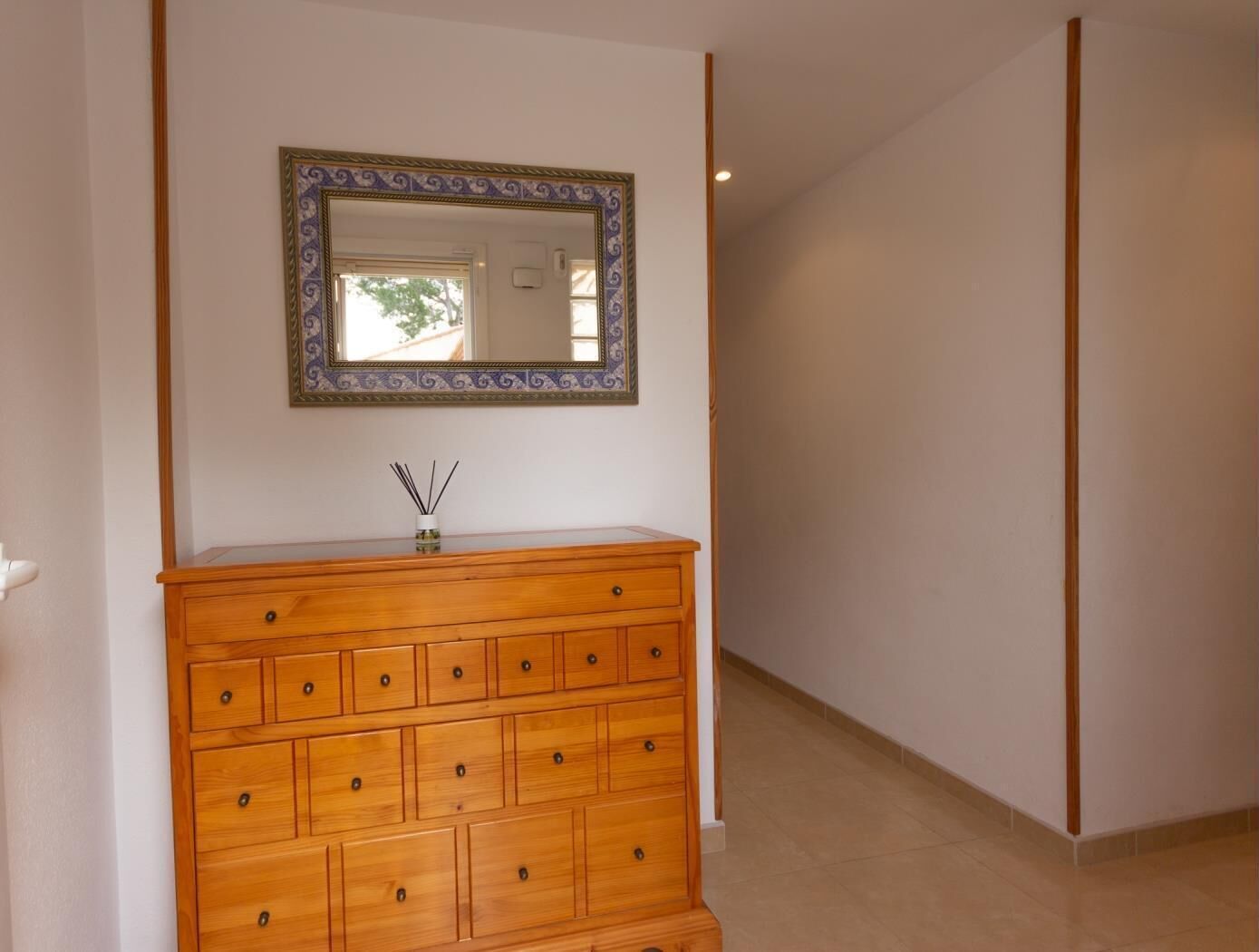 A wooden dresser with drawers and a mirror above it.