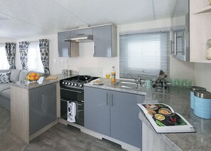 A compact kitchen with a gas stove, oven, and a sink. - 1 bedroom accommodation in Slaley, Hexham (Slaley, Hexham)