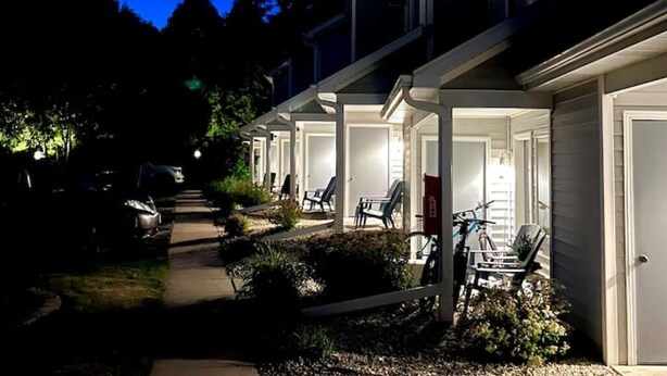 A row of houses with attached garages, a pathway, and outdoor seating areas. - Fish Creek, Door County Condo - Walk to Shopping, Dining & Peninsula State Park (Fish Creek)