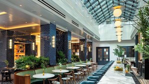 A modern indoor space with a high ceiling, a long bar area, and seating arrangements. - 1-Bedroom Suite at a 4⭐️ Hotel (Nashville)