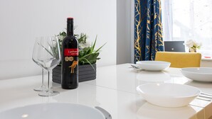 A dining table with a wine bottle, a glass, and white bowls. - Immaculate 3-Bed House in Accrington (Accrington)