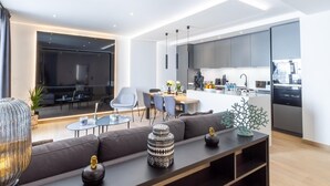 A modern living room with a sofa, coffee table, and a TV area. - Banús, Playas del Duque, Beachfront Residential! (Puerto Banús)