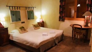 A bedroom with a bed, bedside tables, a chair, and a window.