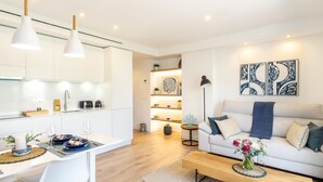 A modern apartment with a kitchen, dining area, and living room. - Banus Playas del Duque Beachside Residential (Puerto Banús)