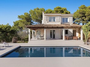Una casa de dos pisos con una piscina del frente.