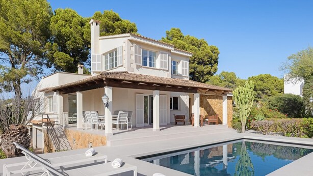 Une maison à deux étages avec une piscine, un espace salon extérieur et un jardin.