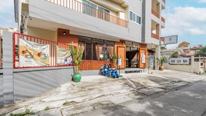 A modern building with a balcony, a signboard, and a scooter parked outside. - Budget Stars Hotel (Chiang Mai)