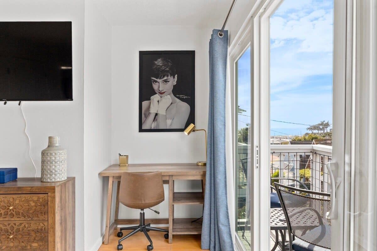 A room with a desk, chair, and a large window with a view.