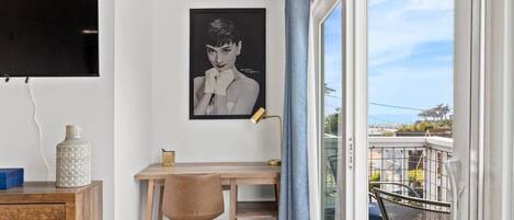 A room with a desk, chair, and a large window with a view.