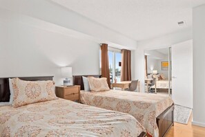 Une chambre d’hôtel avec deux lits, un bureau et une chaise.