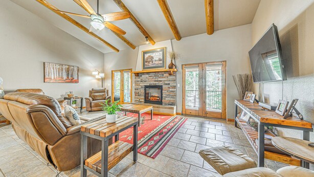 A spacious living room with a fireplace, leather sofas, a wooden coffee table, and a stone floor. - Near Hiking Trails: Spacious Cloudcroft Retreat! (Cloudcroft)