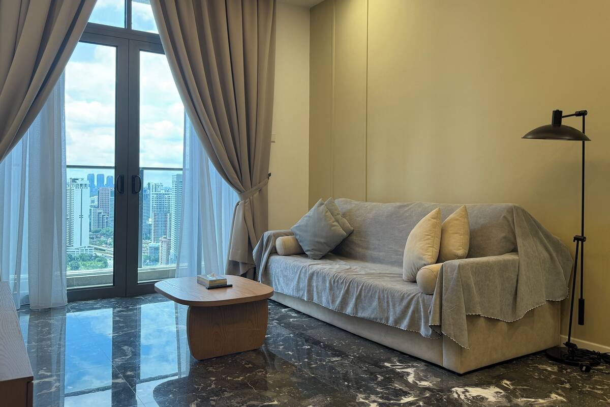 A modern living room with a sofa, a coffee table, and a floor lamp.