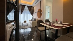 Une chambre d’hôtel moderne dotée d’un coin repas, d’un canapé et offrant une vue sur la ville.