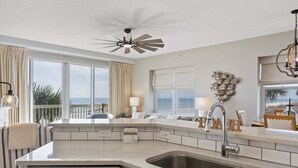 Een moderne keuken met een inbouwvaatwasser, een ruime gootsteen en een plafondventilator.