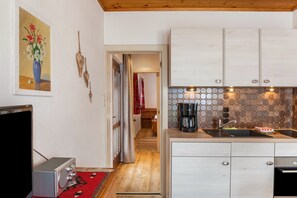 A kitchen with a coffee maker, a sink, and cabinets.