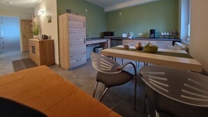 Een moderne keuken met een eethoek, een houten kast en een magnetron.