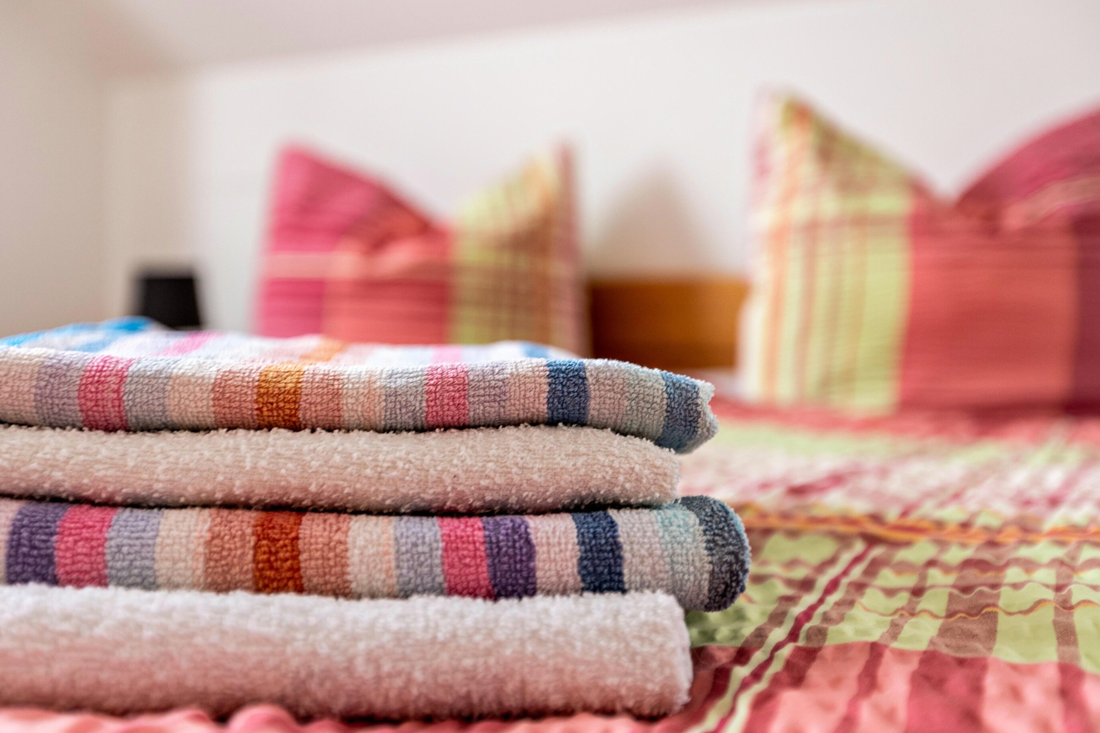 A bed with a colorful quilt and pillows.