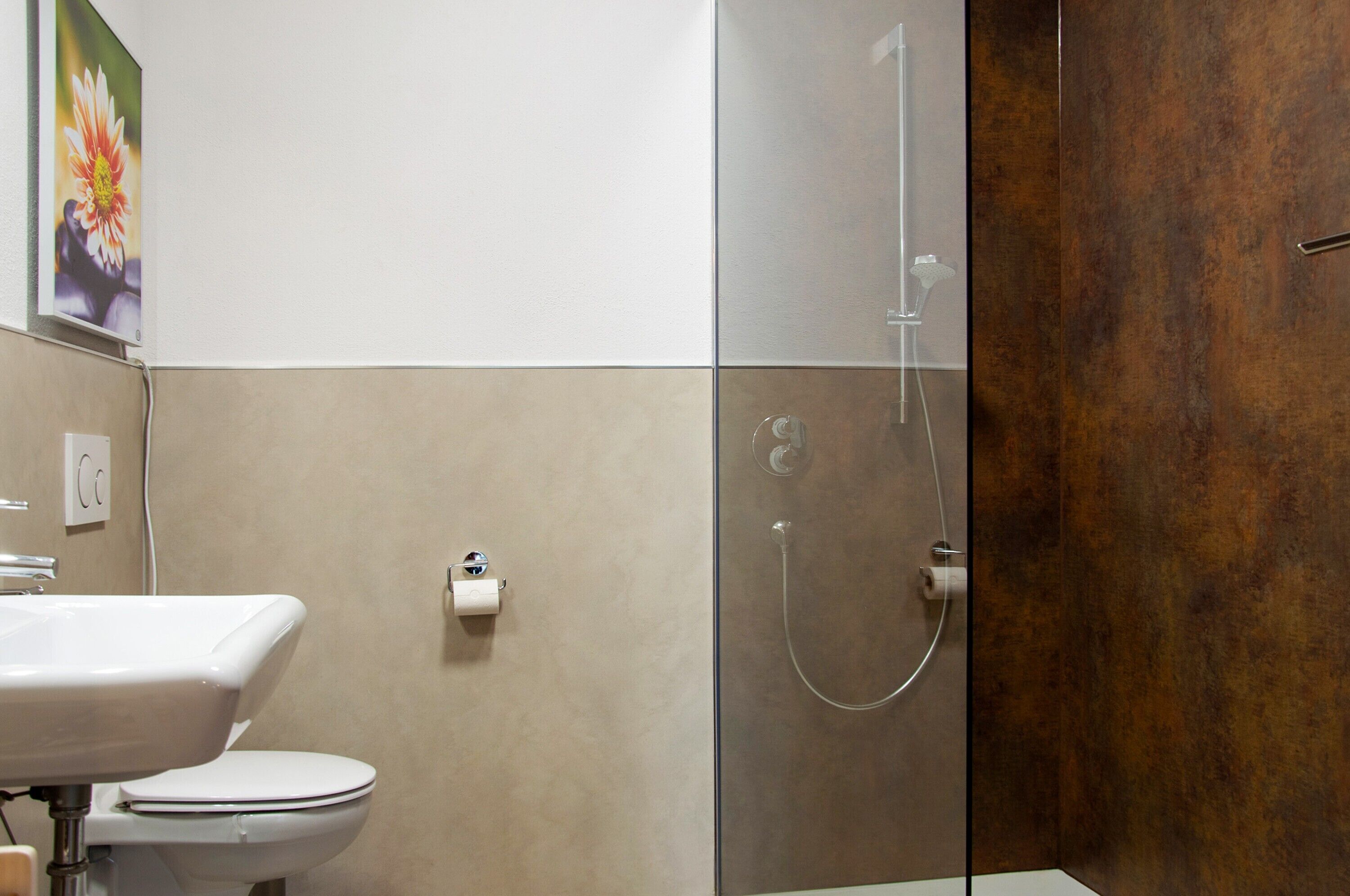A bathroom with a toilet, sink, and shower.