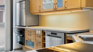 Een moderne keuken met roestvrijstalen apparatuur, houten kastjes en een ingebouwde vaatwasser.