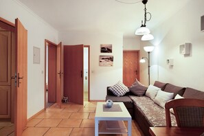 A living room with a sofa, a coffee table, and a lamp.