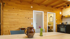 A wooden interior with a dining table, a kitchen area, and a door leading to another room. - Apartment 'St Georgen 1' with Shared Terrace, Balcony and Wi-Fi (Freiburg im Breisgau)